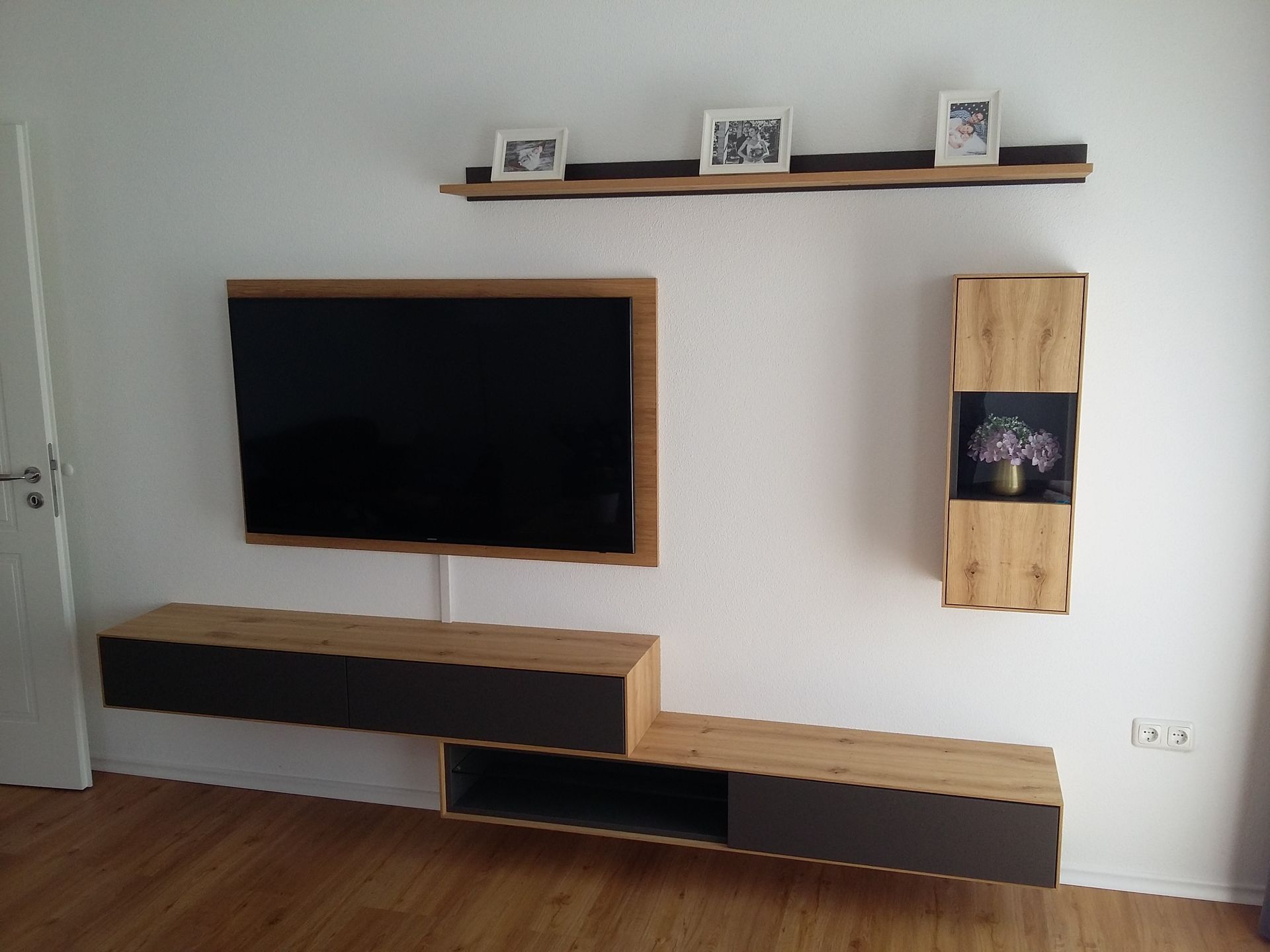 Ein Wohnzimmer mit einem an der Wand montierten Flachbildfernseher