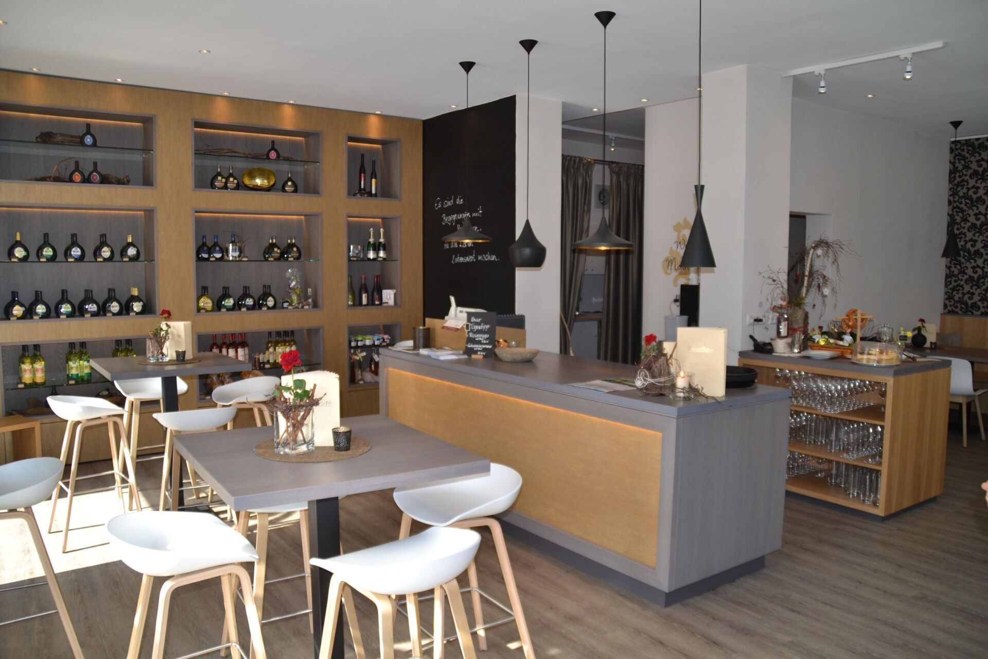 Ein Restaurant mit Tischen und Stühlen und Flaschen auf Regalen