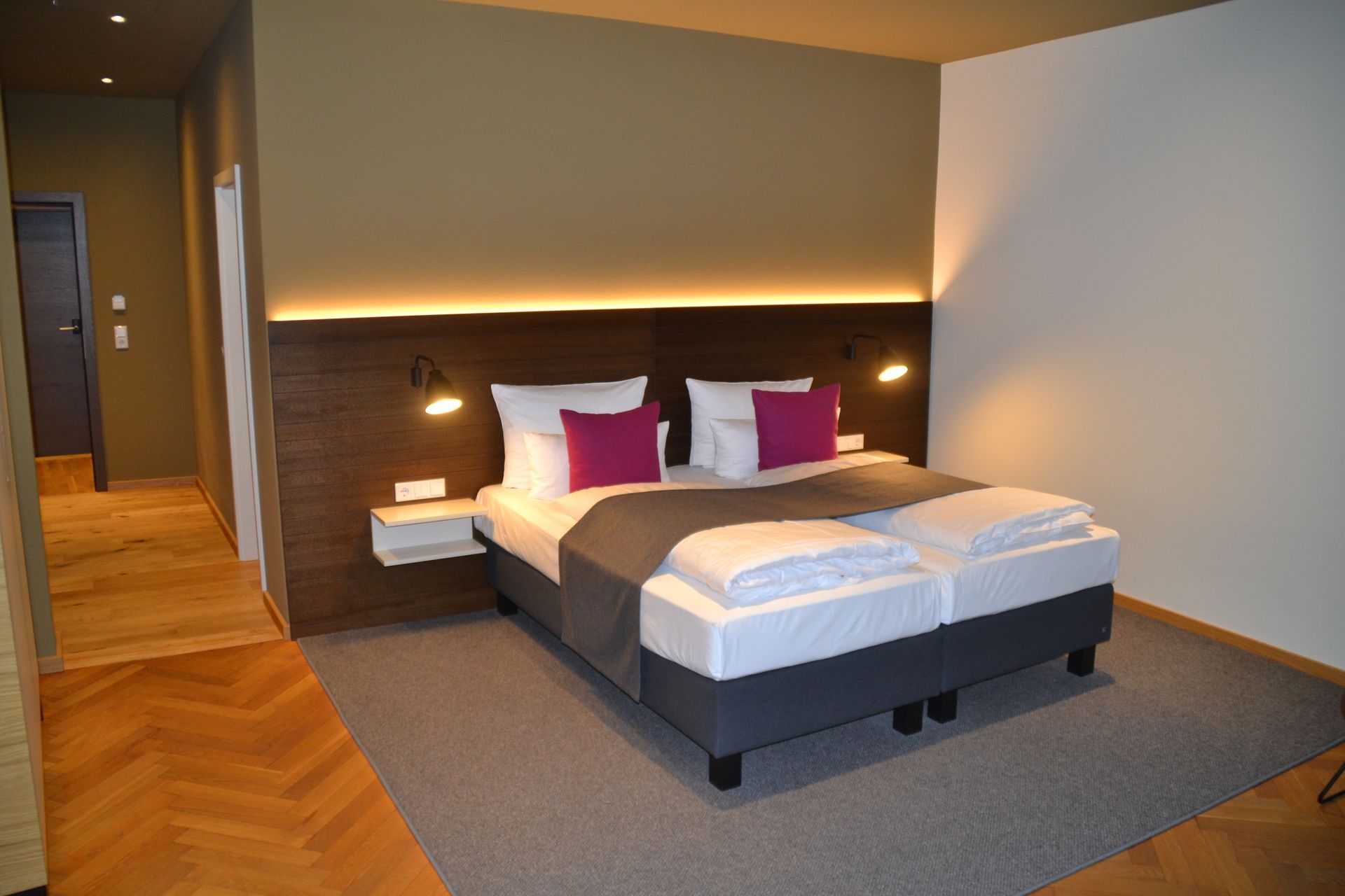 Ein Hotelzimmer mit einem großen Bett und lila Kissen