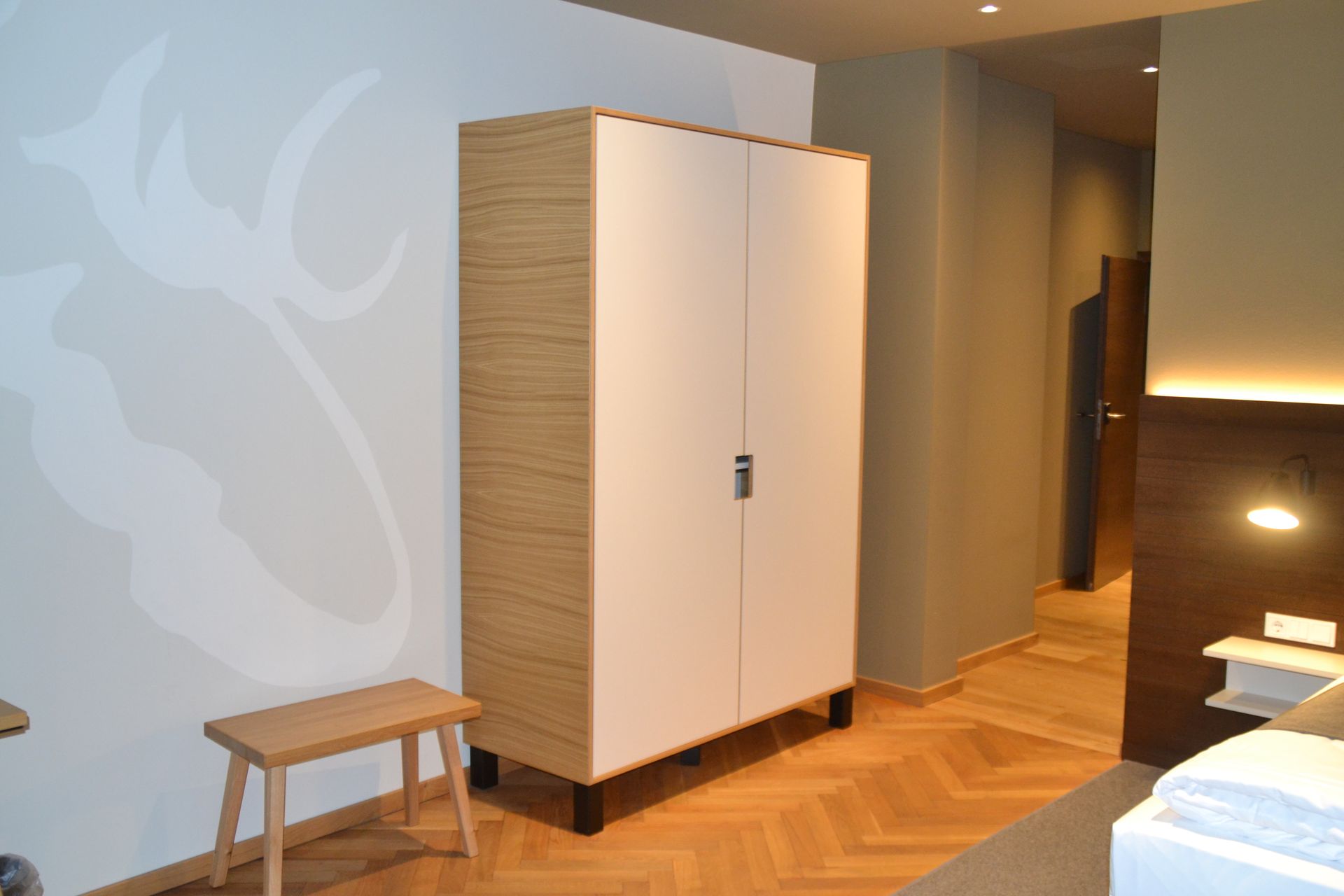 Ein Schlafzimmer mit einem Kleiderschrank und einer Bank darin