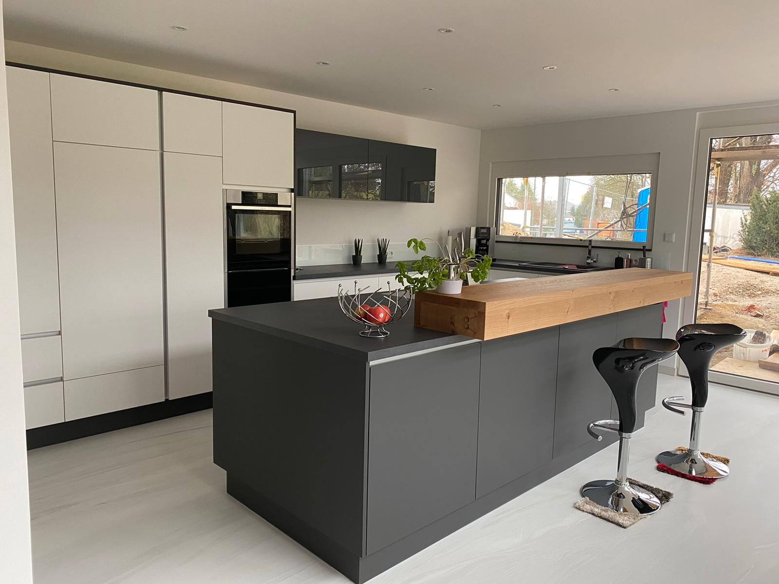 Eine Küche mit einer großen Kochinsel und zwei Barhockern.