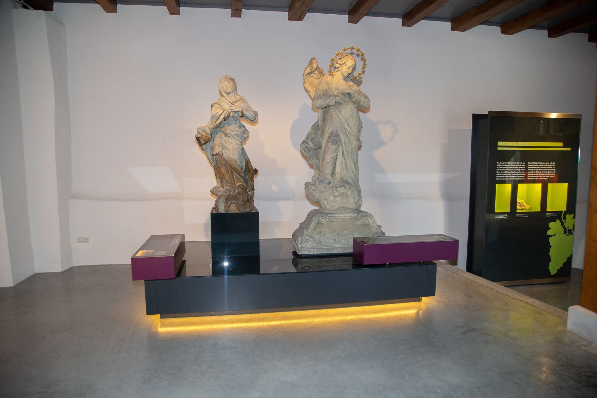 Zwei Statuen sitzen auf einem Tisch in einem Raum