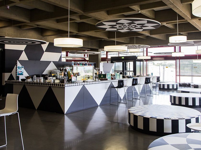 Ein Restaurant mit einem schwarz-weiß karierten Tisch und Stühlen