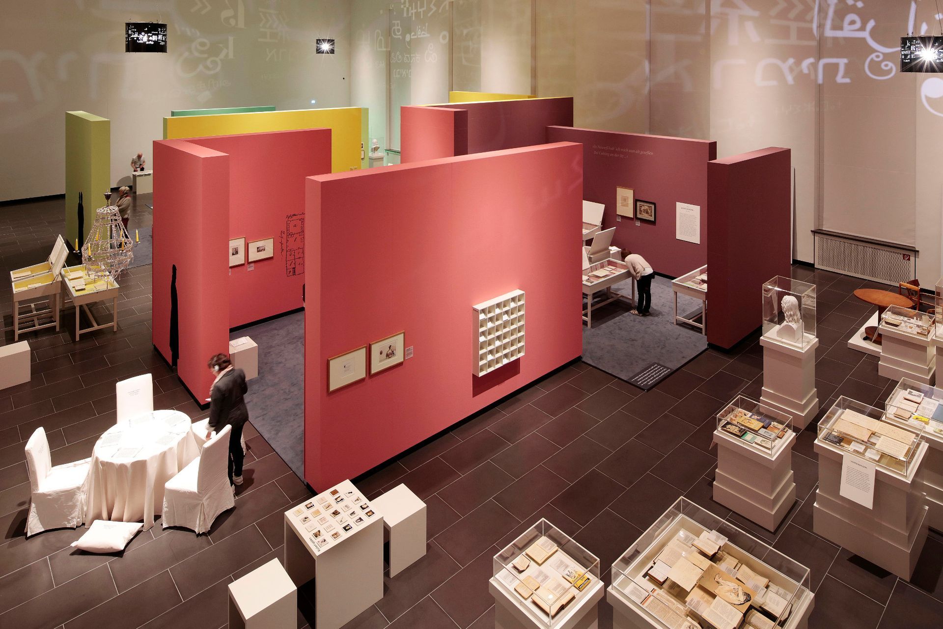 Ein großer Raum mit rosa Wänden und weißen Stühlen