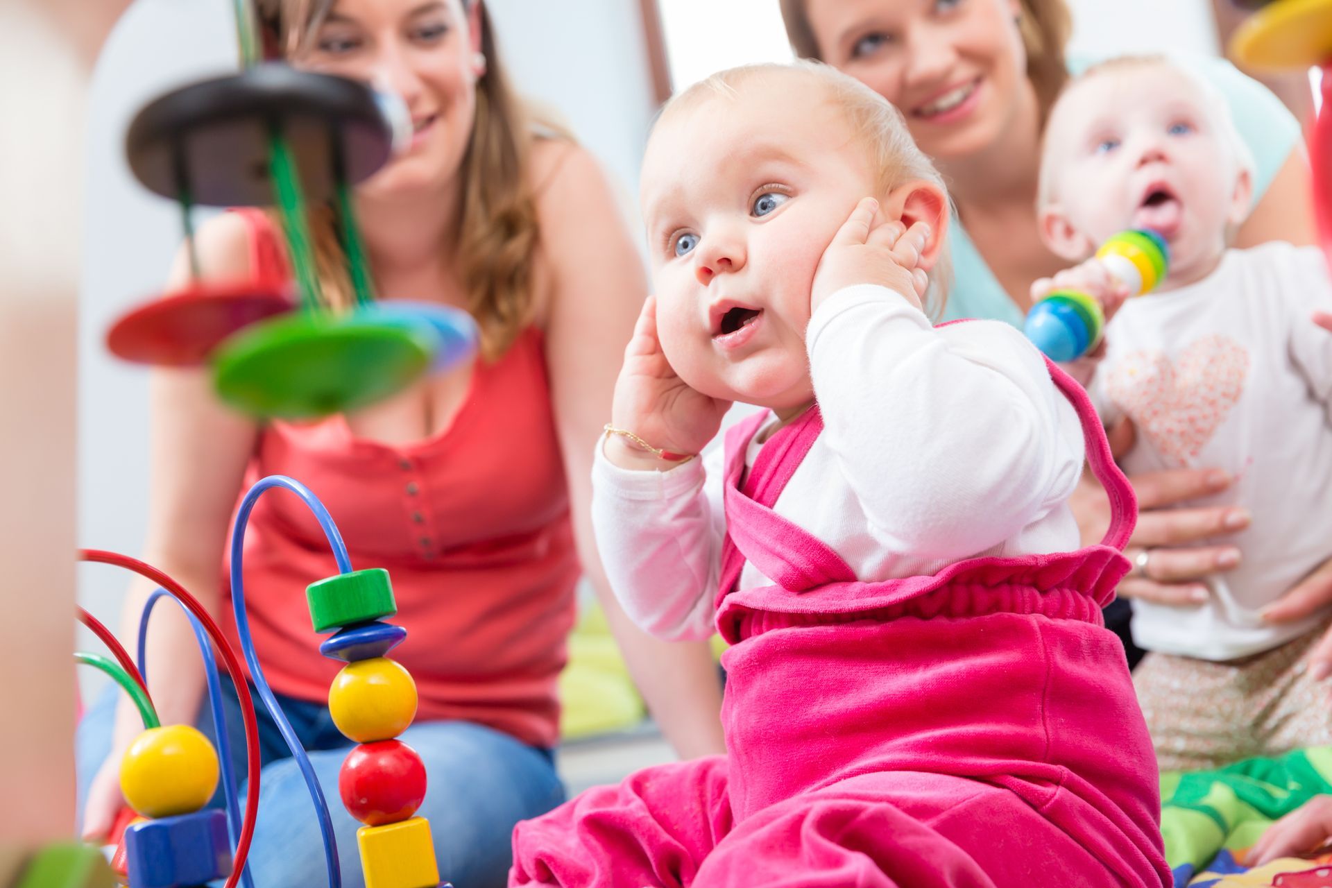 Enfant en bas âge découvre des jouets d’éveil colorés lors d’une activité ludique
