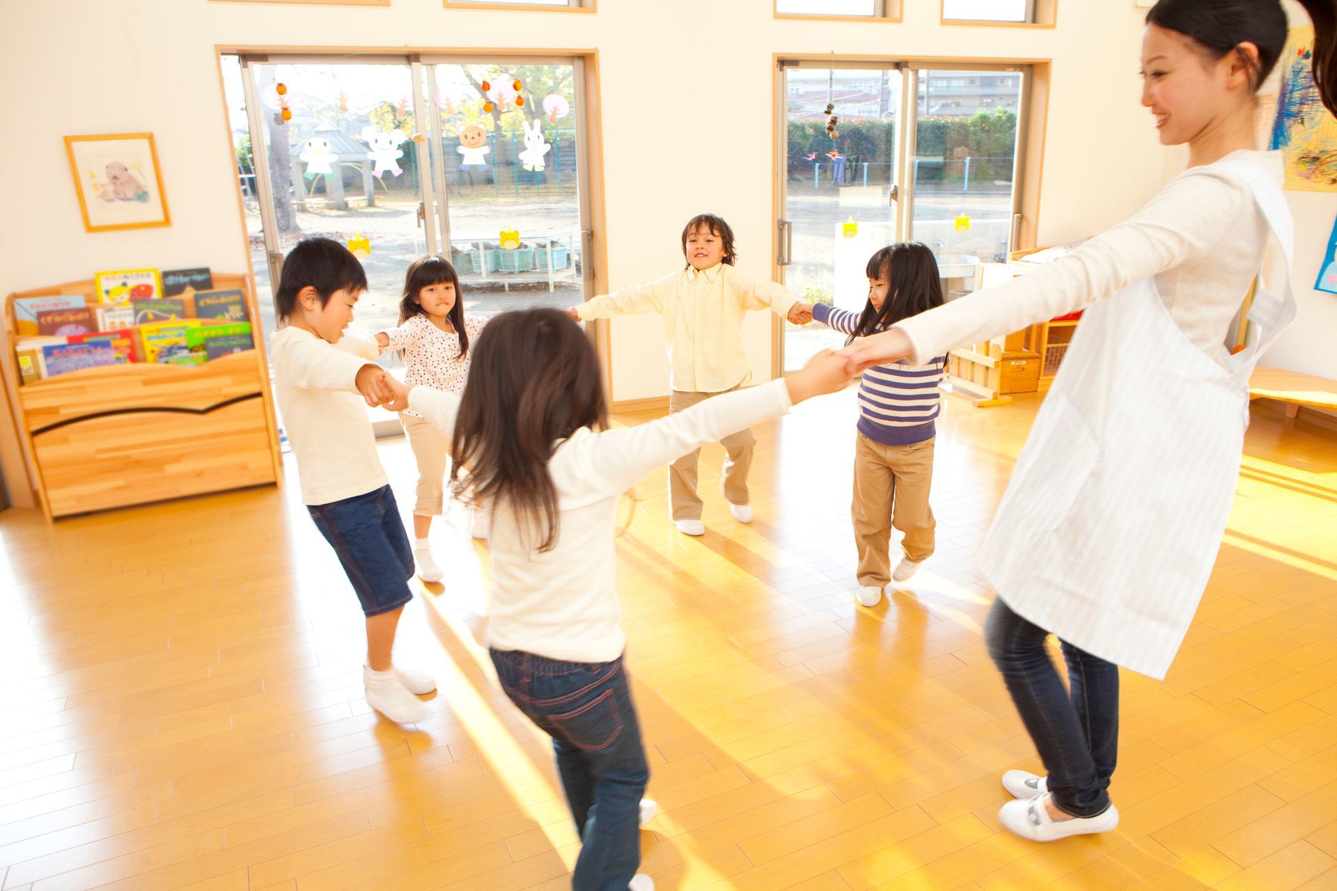 Des enfants et une animatrice dansent en cercle