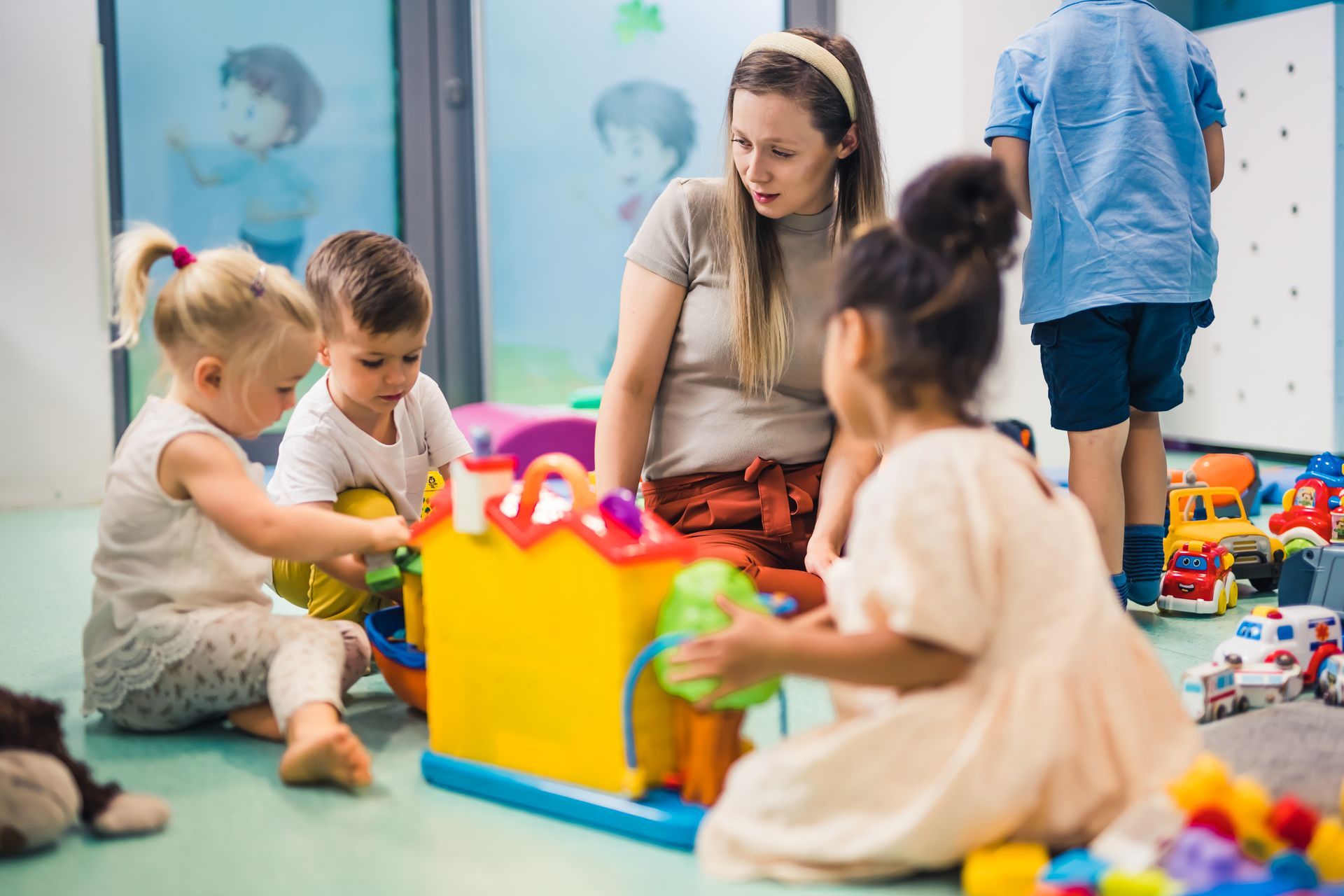 Des enfants et un adulte jouent avec des jouets dans une crèche