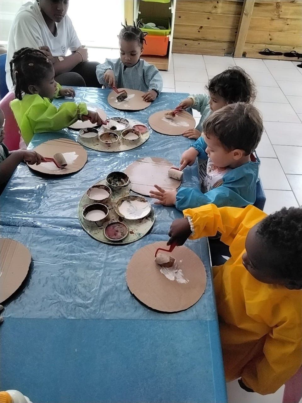Des enfants jouent avec des blocs de bois colorés sur un tapis