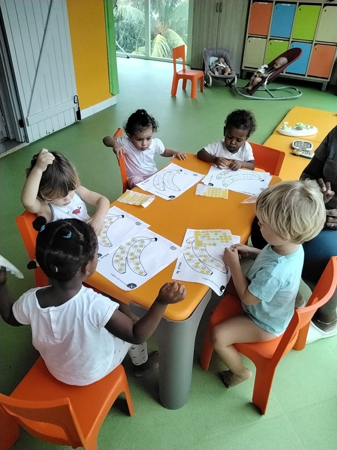 Enfant dessinant à une table blanche avec des crayons de couleur