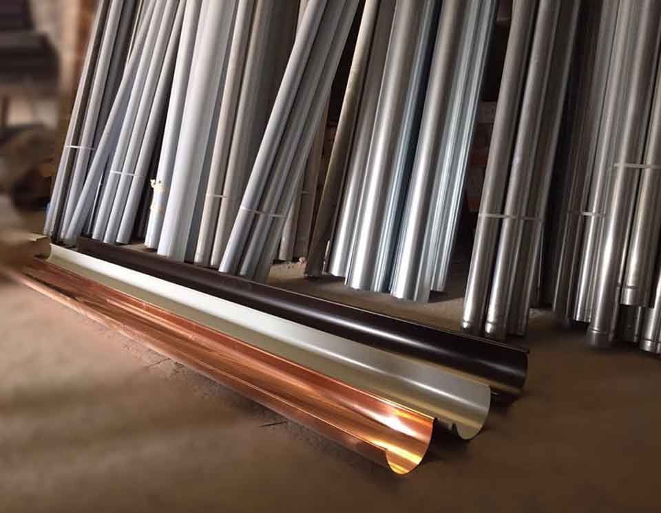 Un montón de tubos de metal están apilados uno encima del otro.