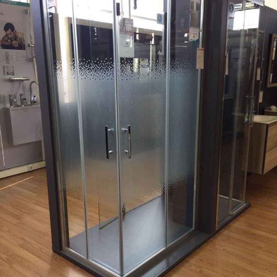 Una cabina de ducha con puertas corredizas de vidrio en un baño.