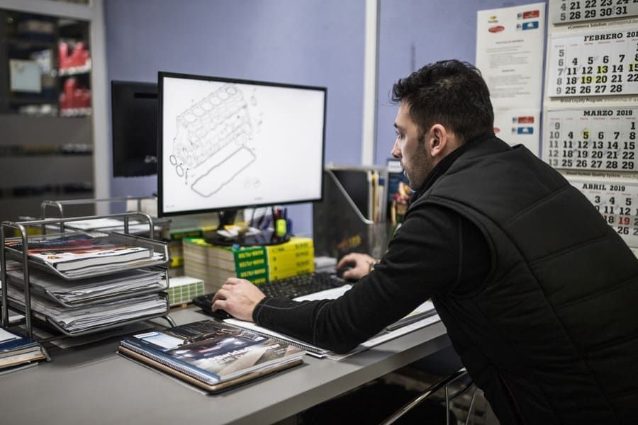 Un hombre está sentado en un escritorio trabajando en una computadora.