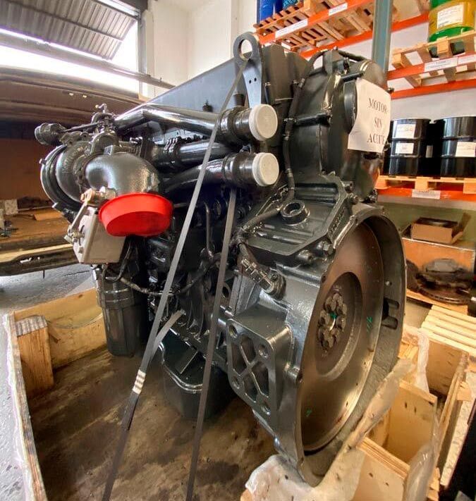 Un motor grande está en una caja de madera en un almacén.