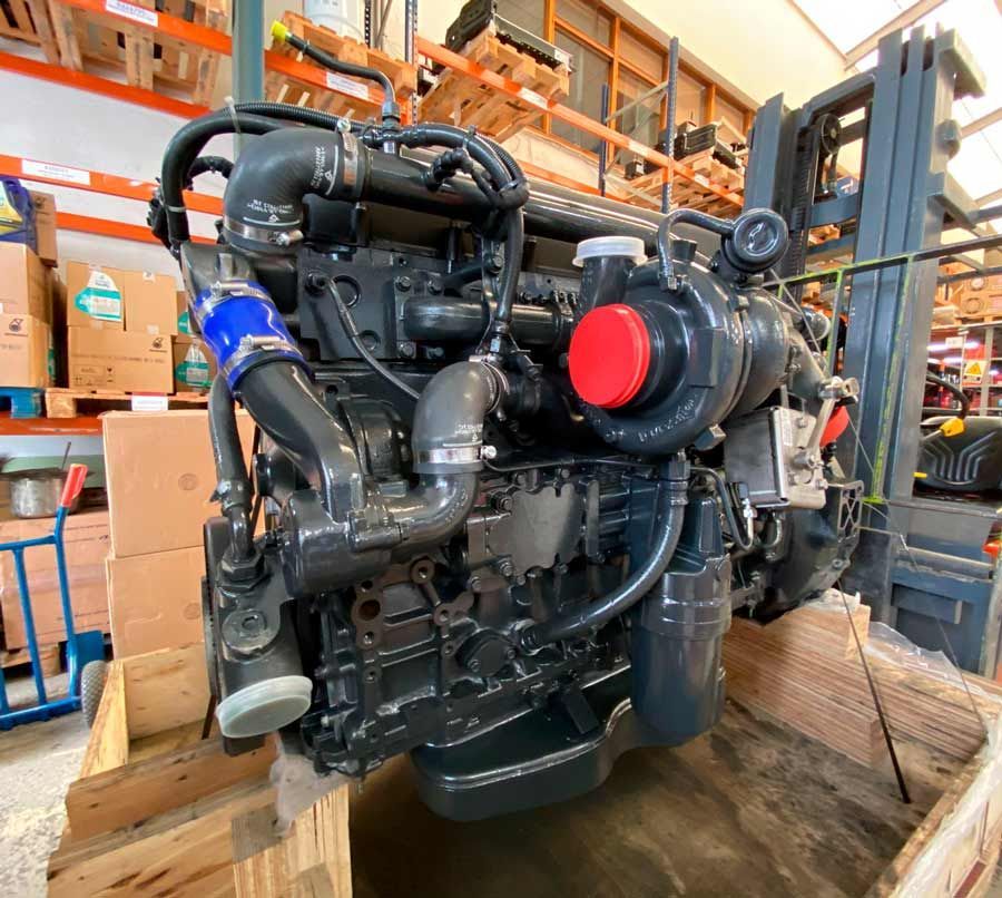 Un motor grande está dentro de una caja de madera en un almacén.