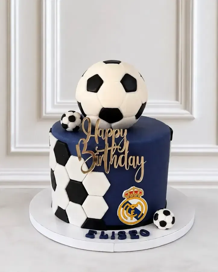 Tarta de cumpleaños azul del Real Madrid decorada con balones de fútbol y adorno dorado de