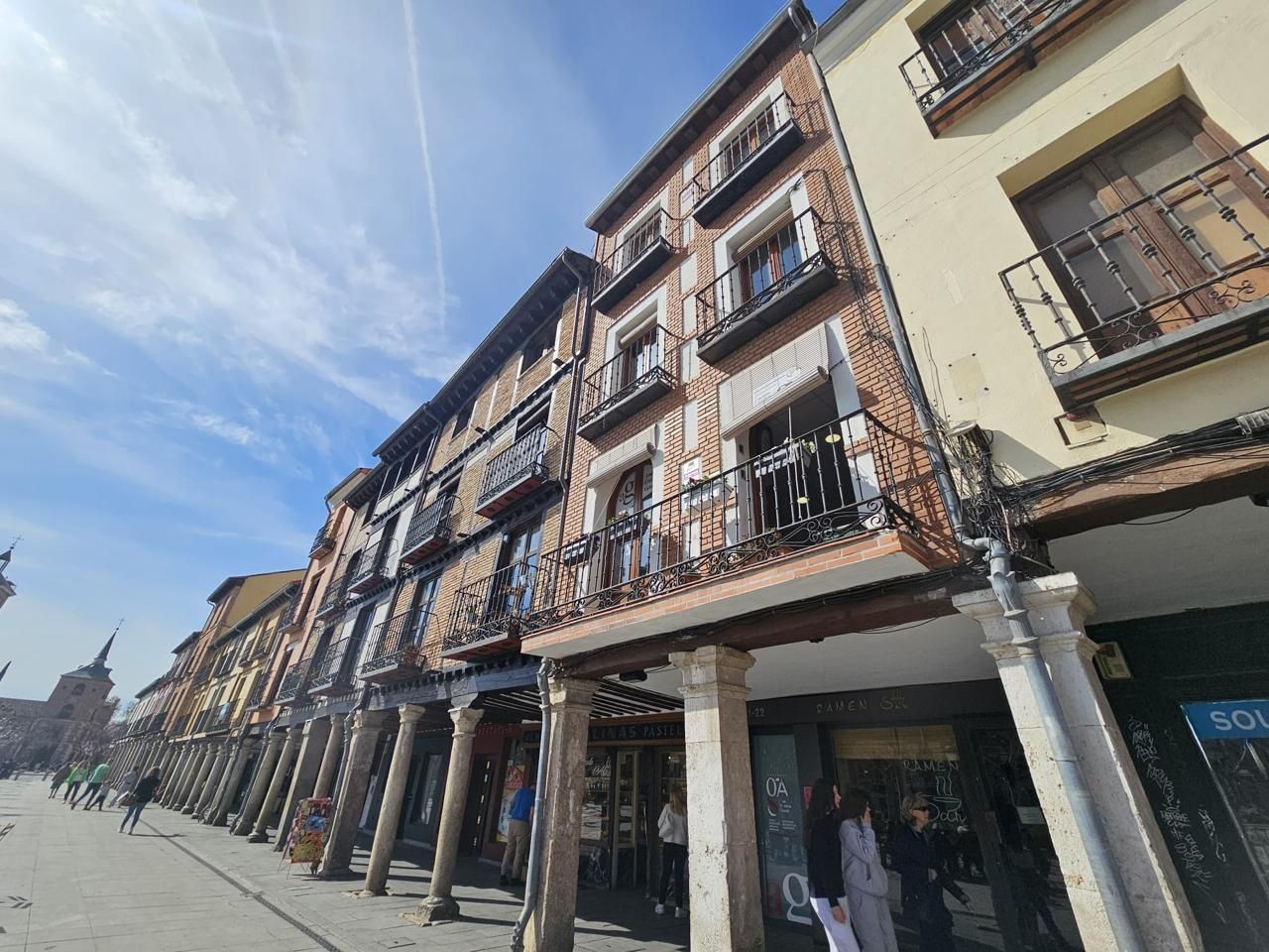 Un dormitorio con una cama, un banco, un escritorio y estantes.