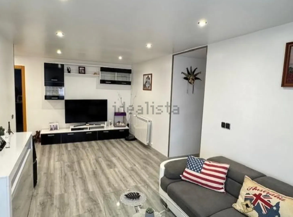 Una sala de estar con un sofá y un televisor de pantalla plana.
