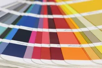 Abanico de muestras de color que muestra una paleta impresa con azules, rosas, naranjas y rojos.