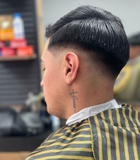 Un hombre con un tatuaje de cruz en el cuello