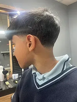 Un niño pequeño se está cortando el pelo en una barbería.