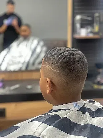 Un niño pequeño se está cortando el pelo en una barbería.