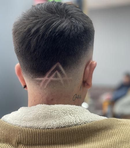 Un hombre con la letra a tallada en su cabello