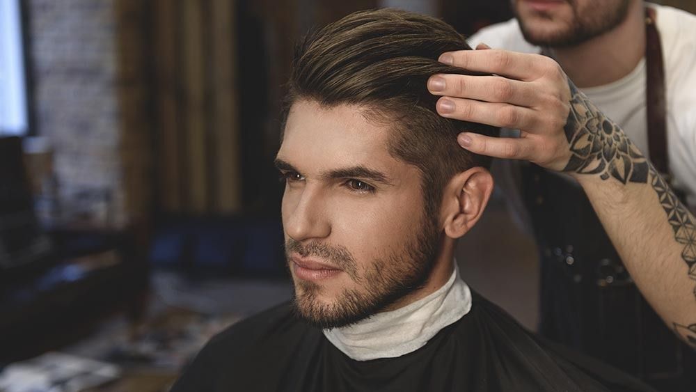 Un hombre se está cortando el pelo en una barbería.