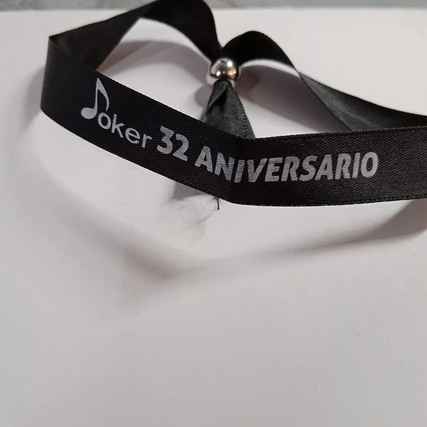 Una cinta negra con el Joker 32 aniversario escrito en ella
