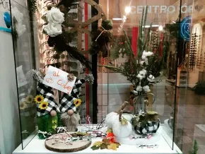 Un escaparate de tienda con flores y gnomos.