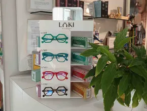Una exhibición de vasos en una tienda con una planta al fondo.