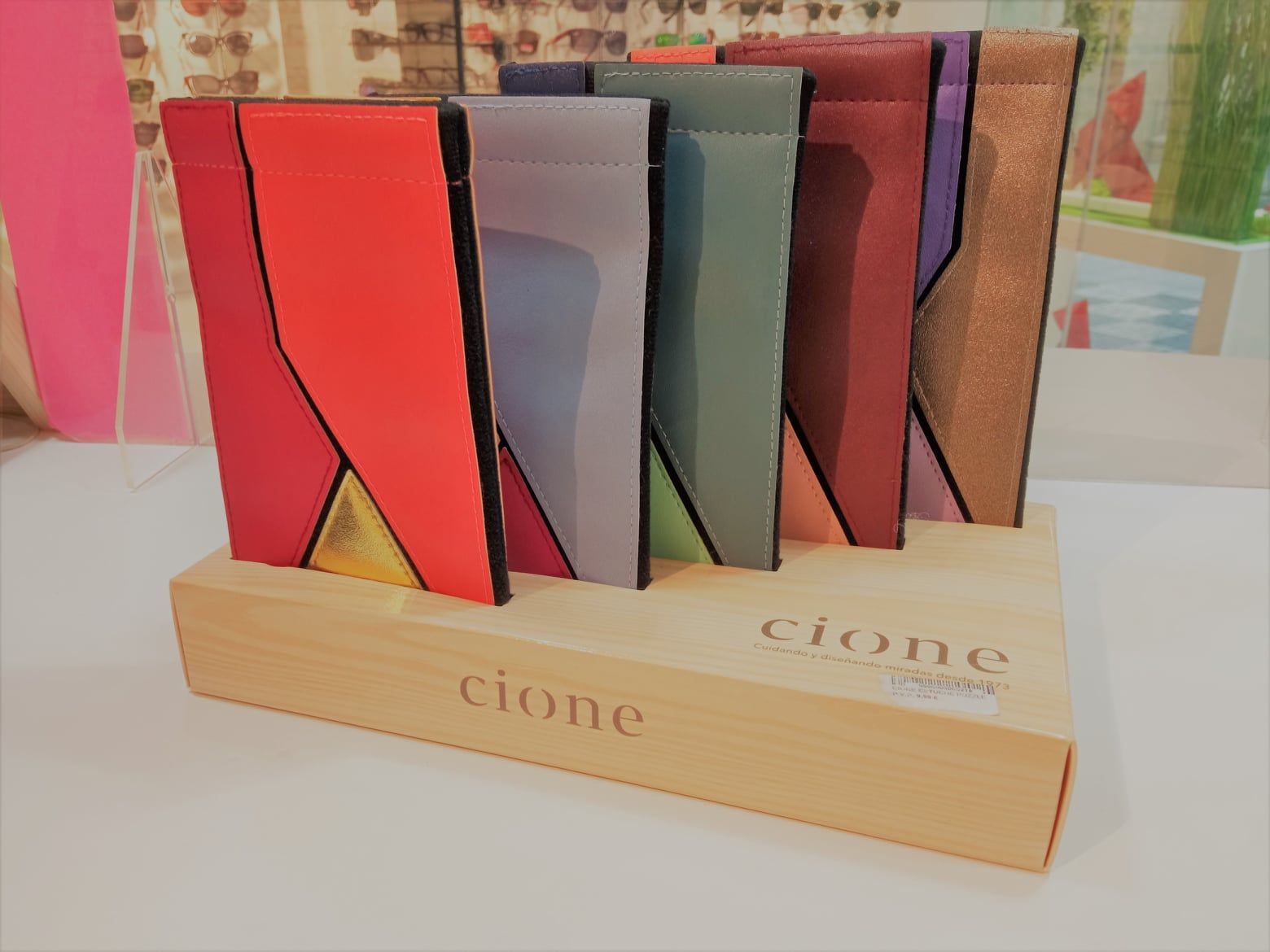 Una exhibición de madera con un montón de papeles de diferentes colores encima.