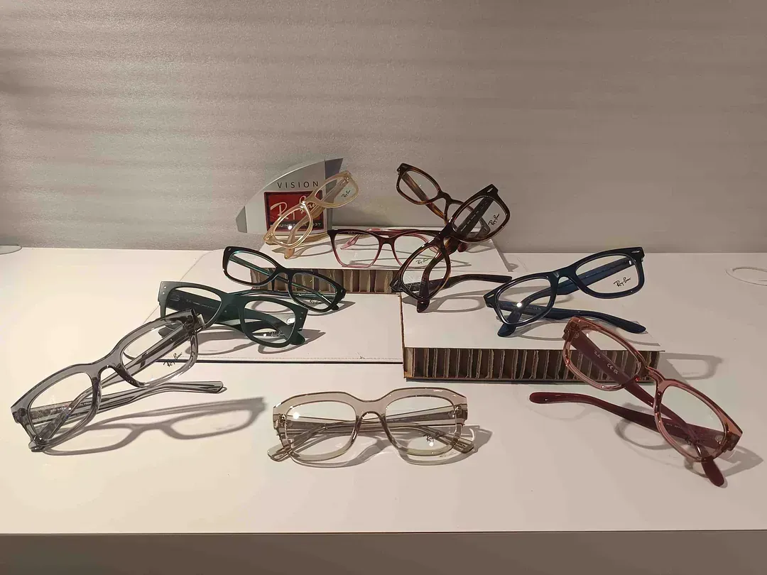 Una exposición de vasos en una tienda con una planta en primer plano.
