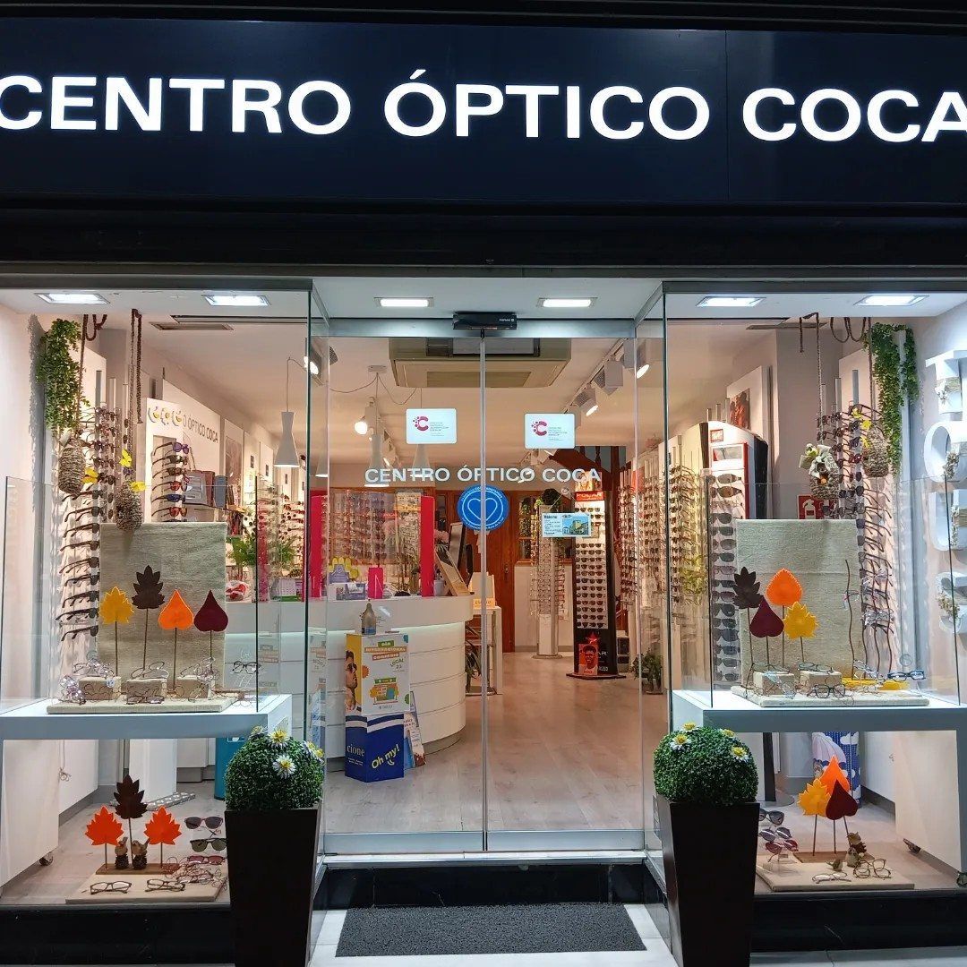 Un escaparate con un cartel que dice centro óptico coca