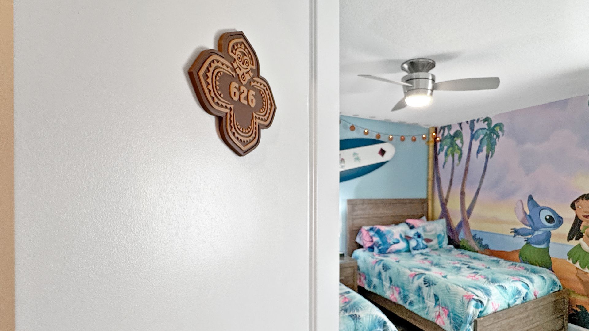 A bedroom with a lilo and stitch mural on the wall.