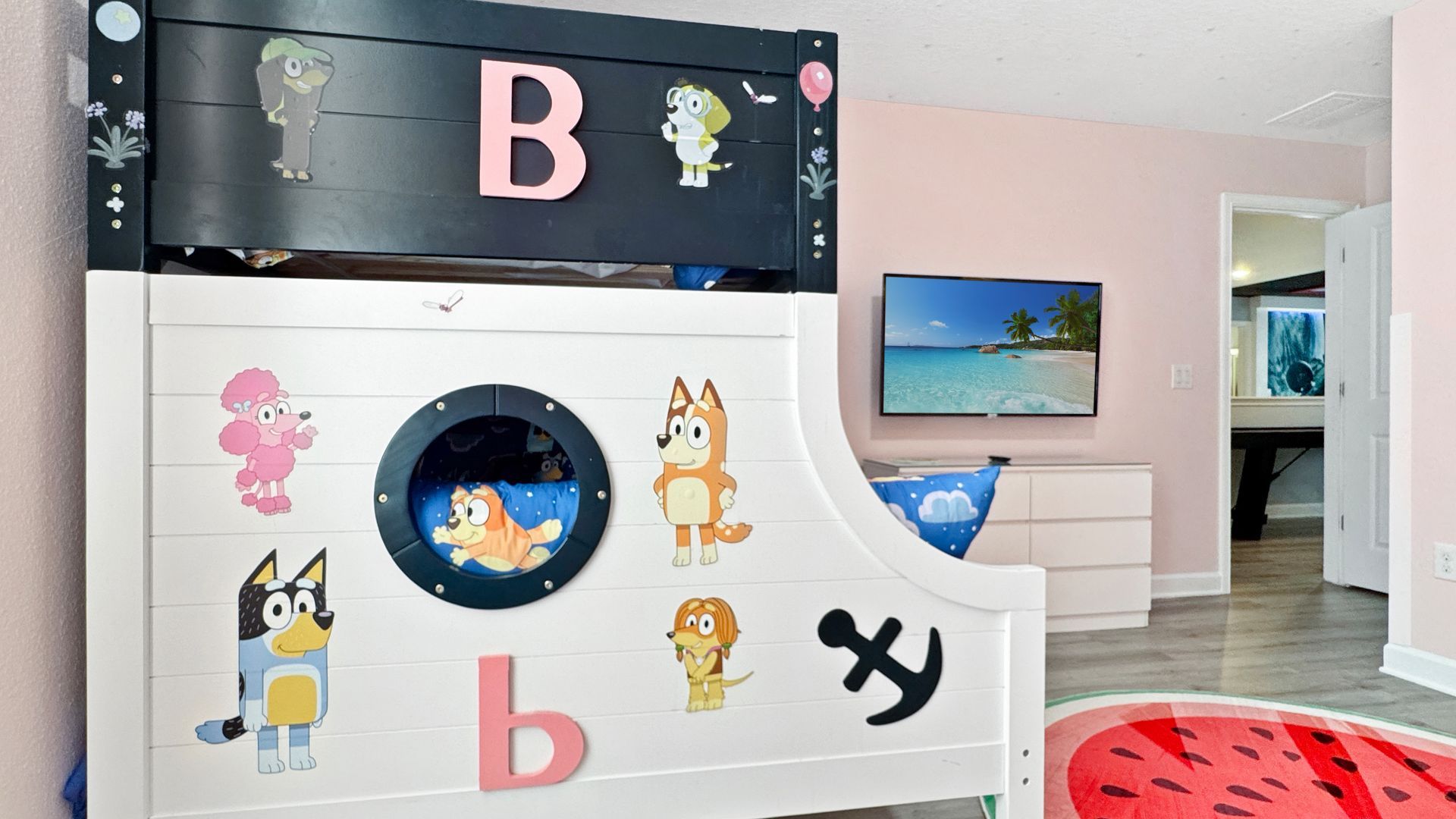 A bedroom with a bunk bed and a television.