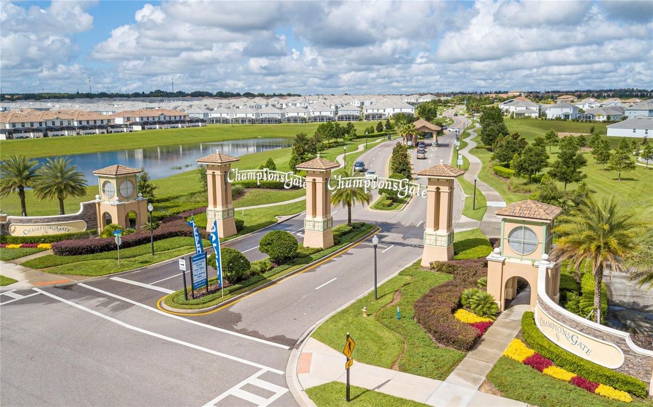 An aerial view of a gated community with a lake in the background.
