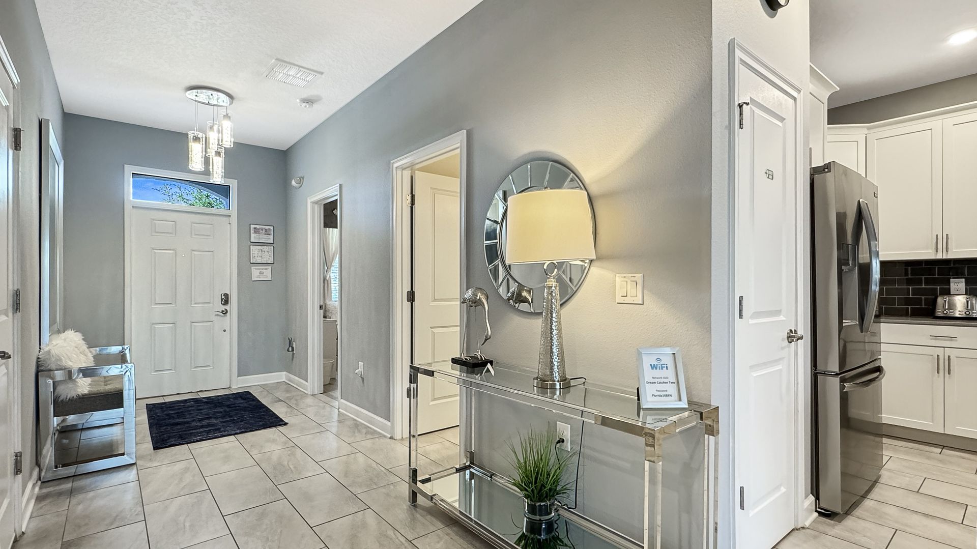 A hallway in a house with a table and a mirror on the wall.