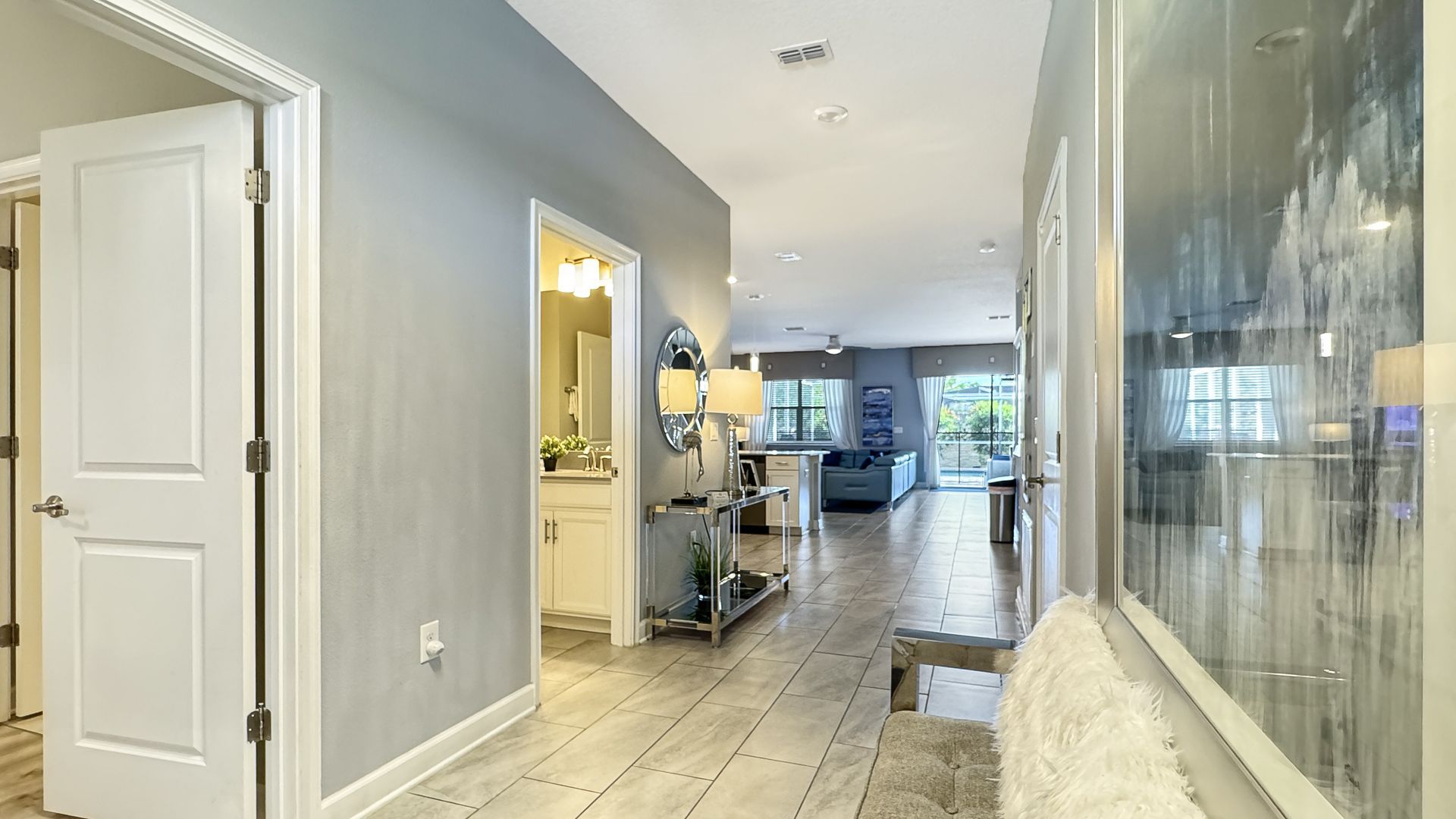 A hallway in a house with a bench and a painting on the wall.