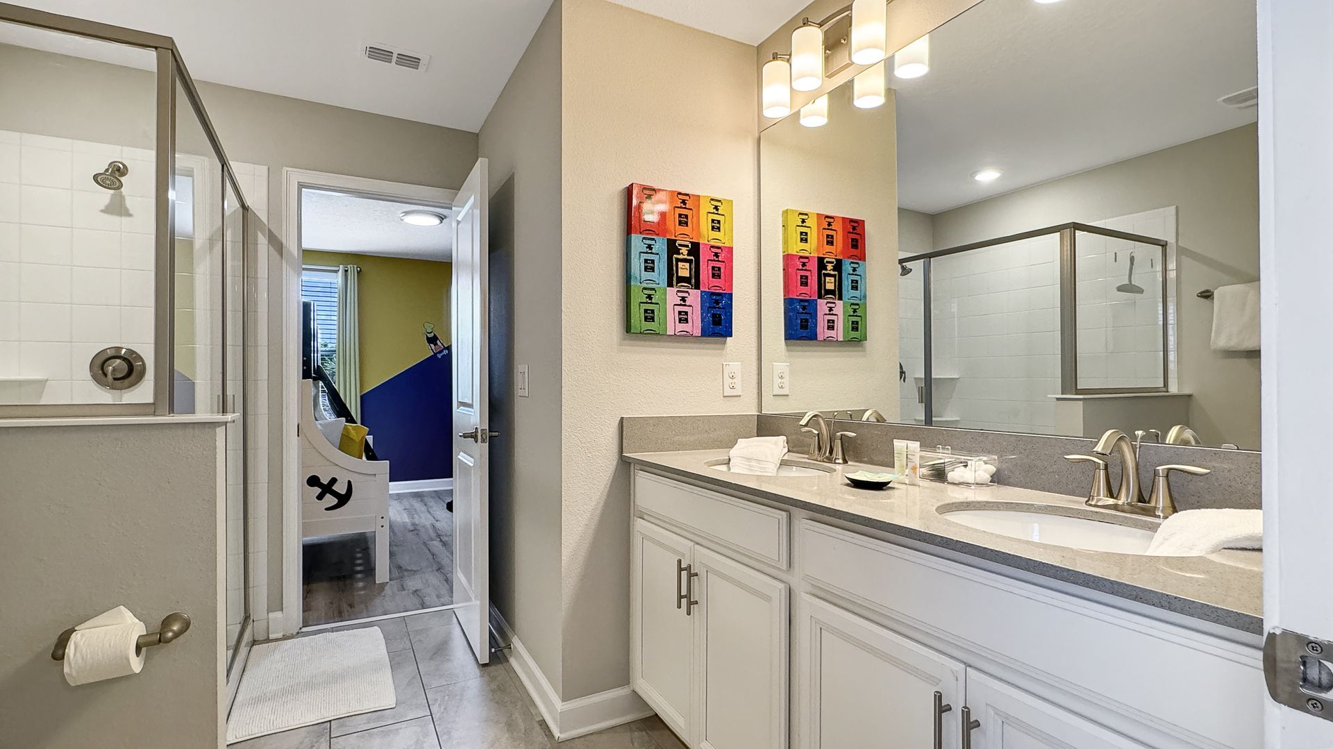 A bathroom with two sinks , a shower and a mirror.
