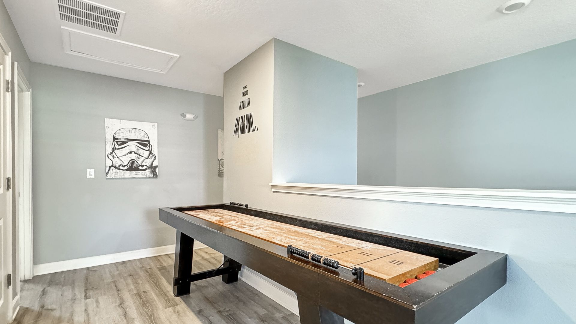 There is a shuffleboard table in the middle of the room.