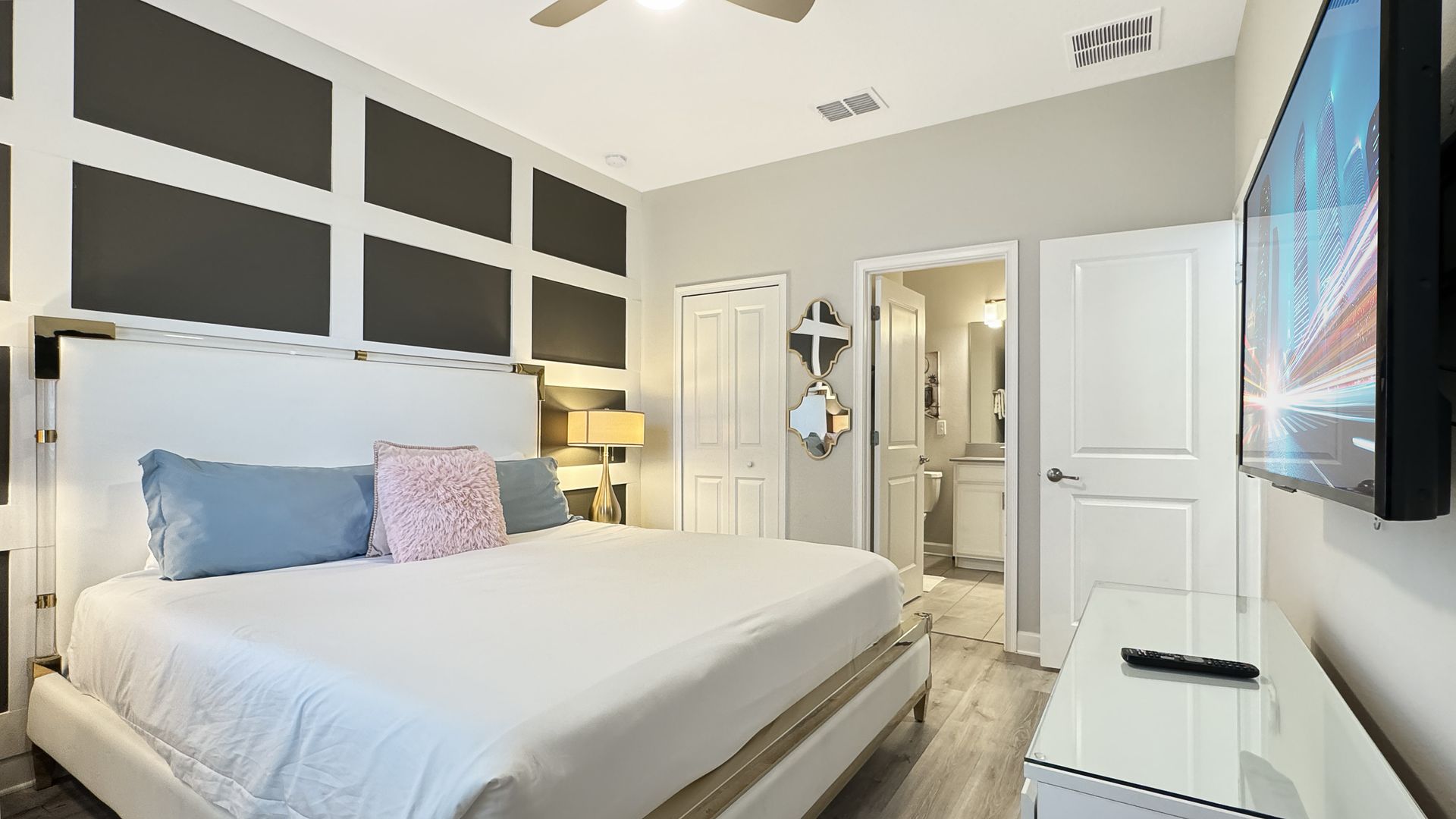 A bedroom with a king size bed and a flat screen tv.