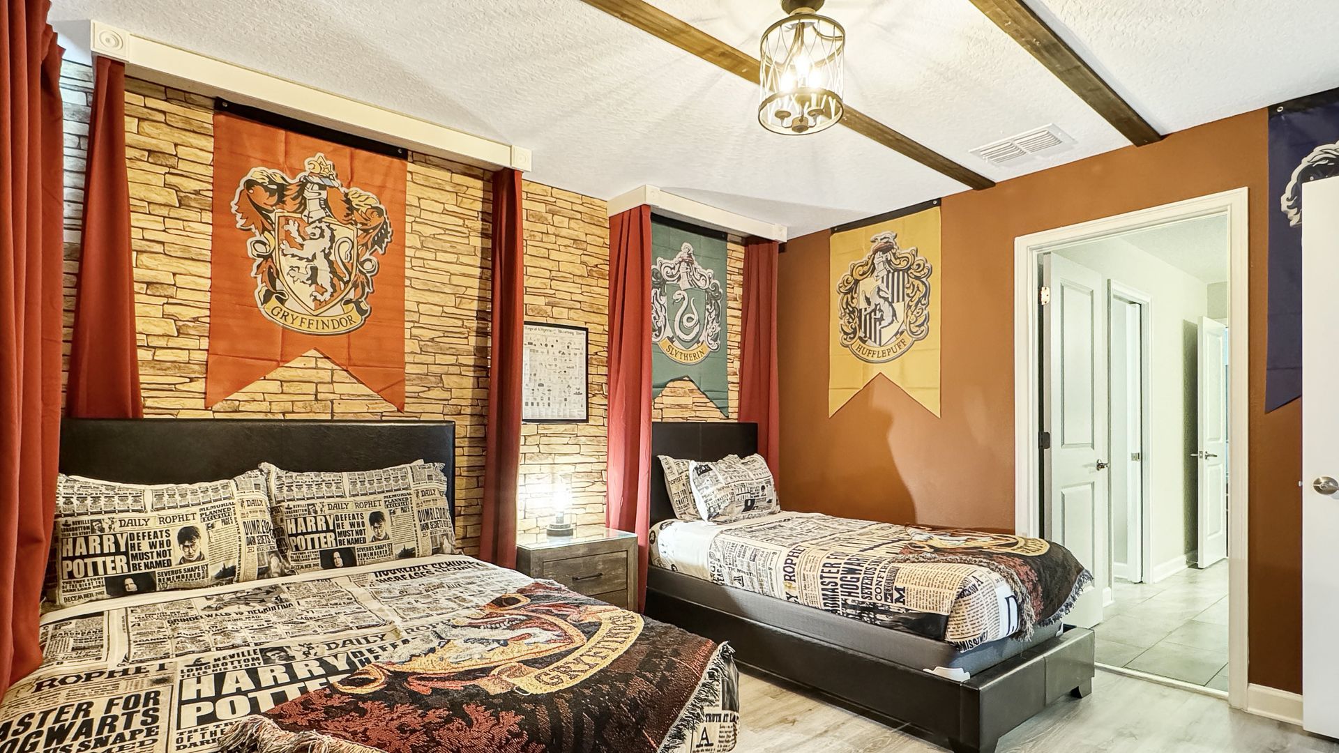 There are two beds in the room with a harry potter theme.