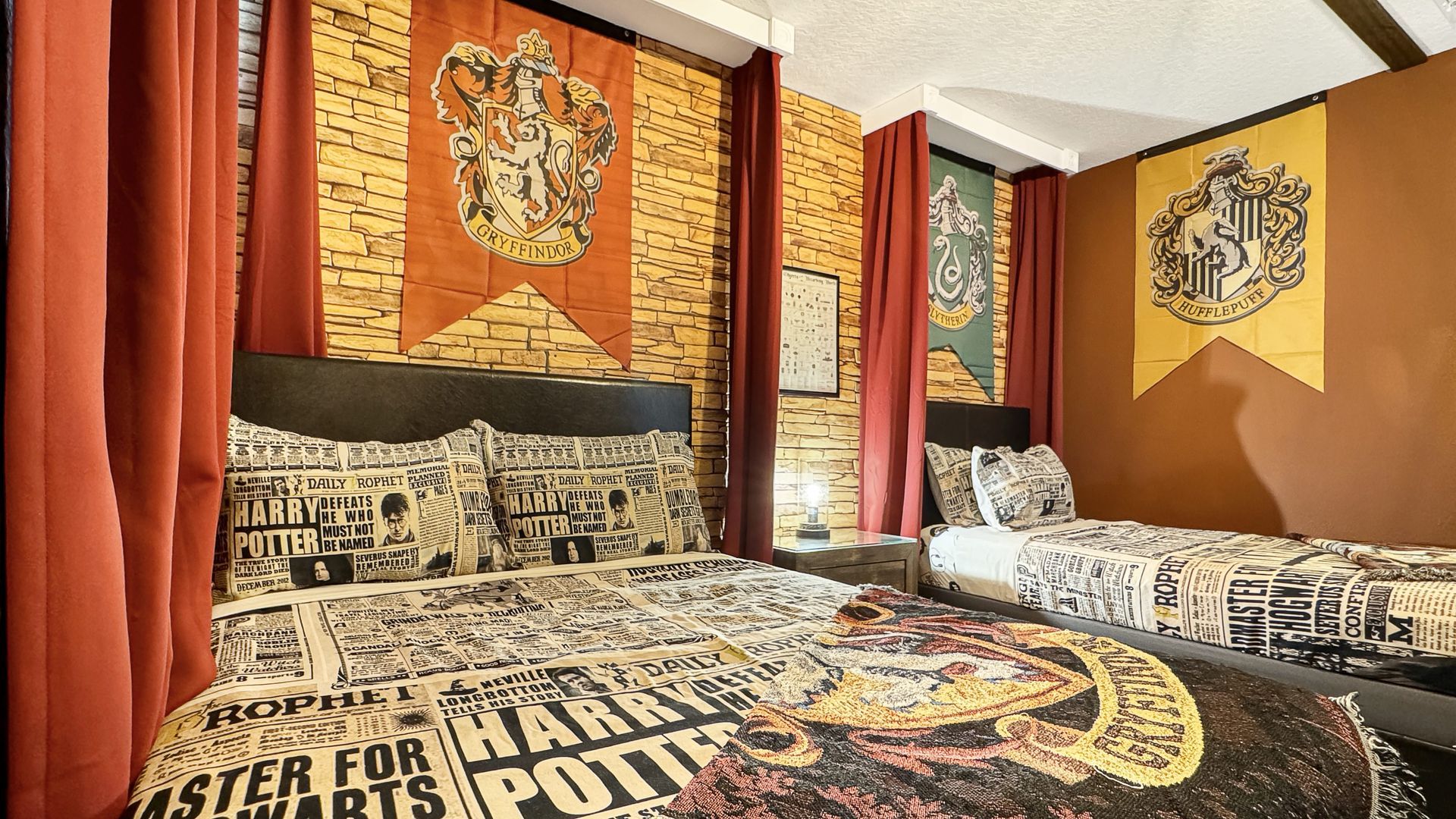A bedroom with two beds and a harry potter theme.