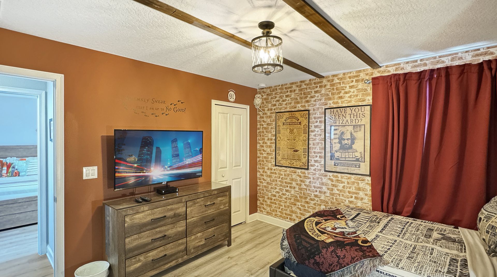 A bedroom with a bed , dresser , and television.