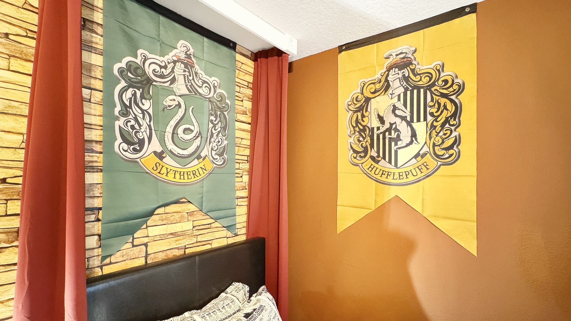 A bedroom with two harry potter flags hanging on the wall.
