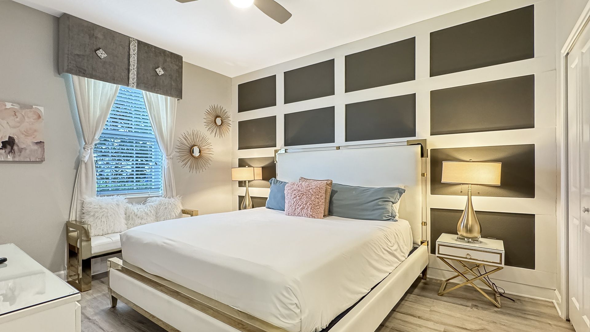 A bedroom with a large bed and a ceiling fan.