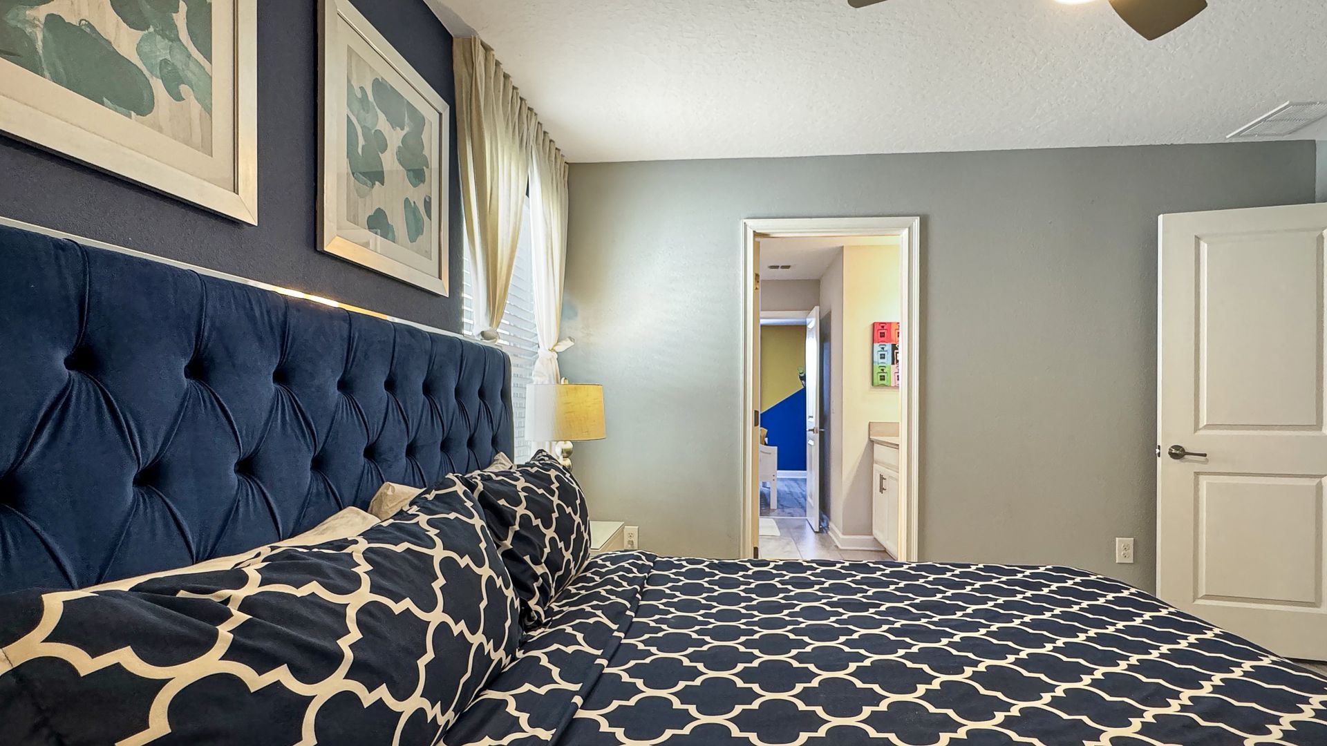 A bedroom with a large bed and a ceiling fan.