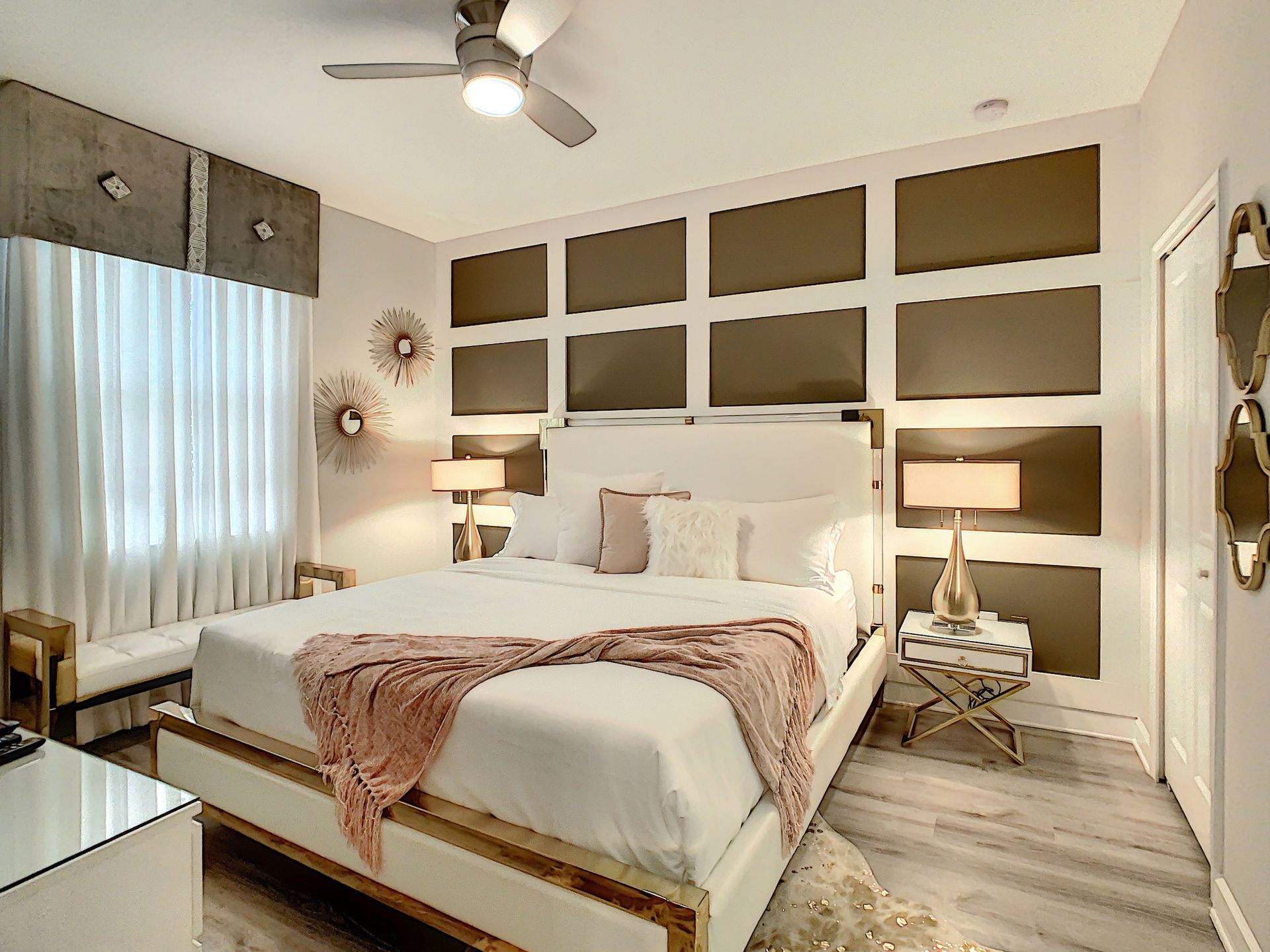 A bedroom with a king size bed and a ceiling fan.