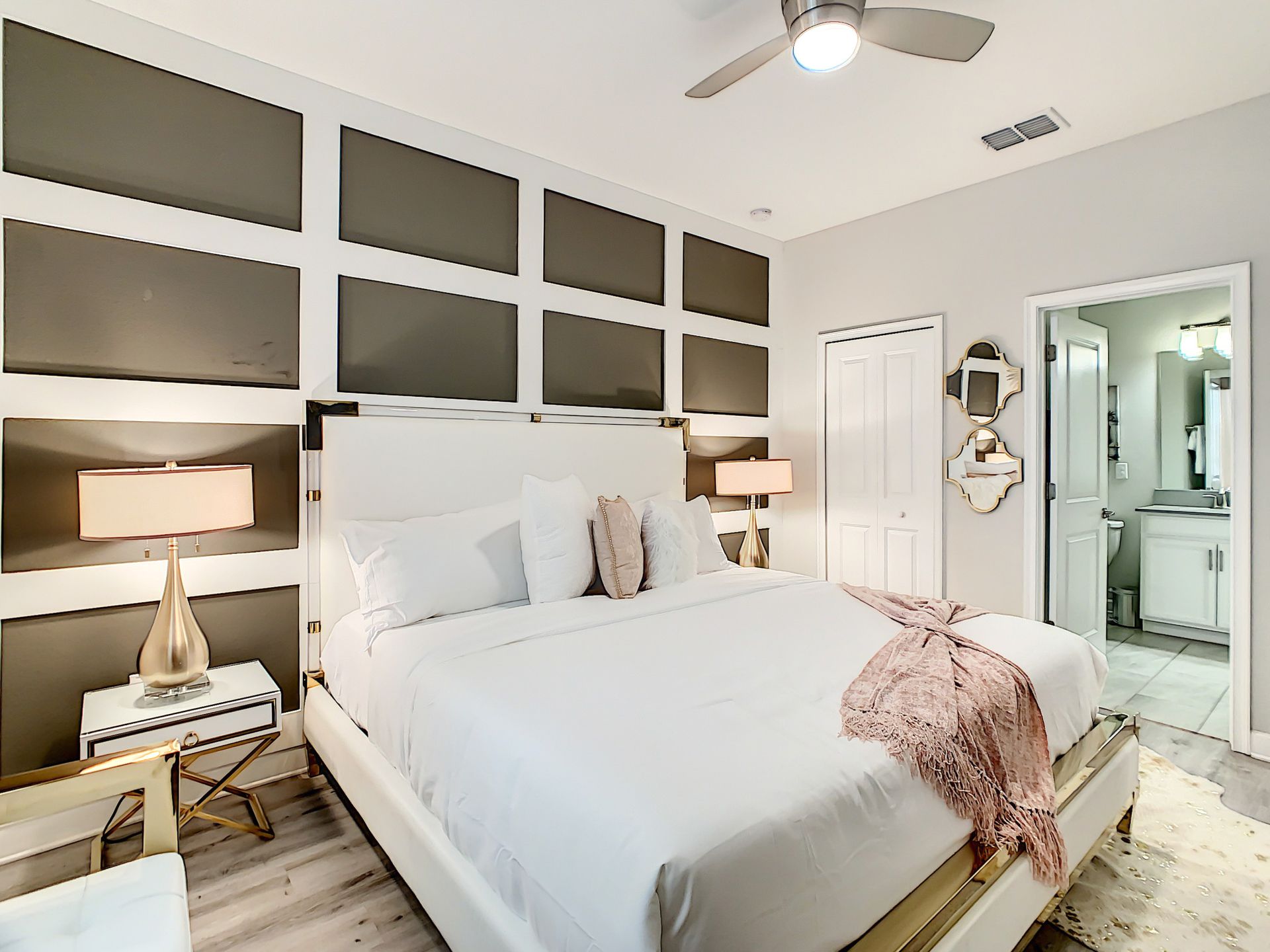 A bedroom with a king size bed and a ceiling fan.