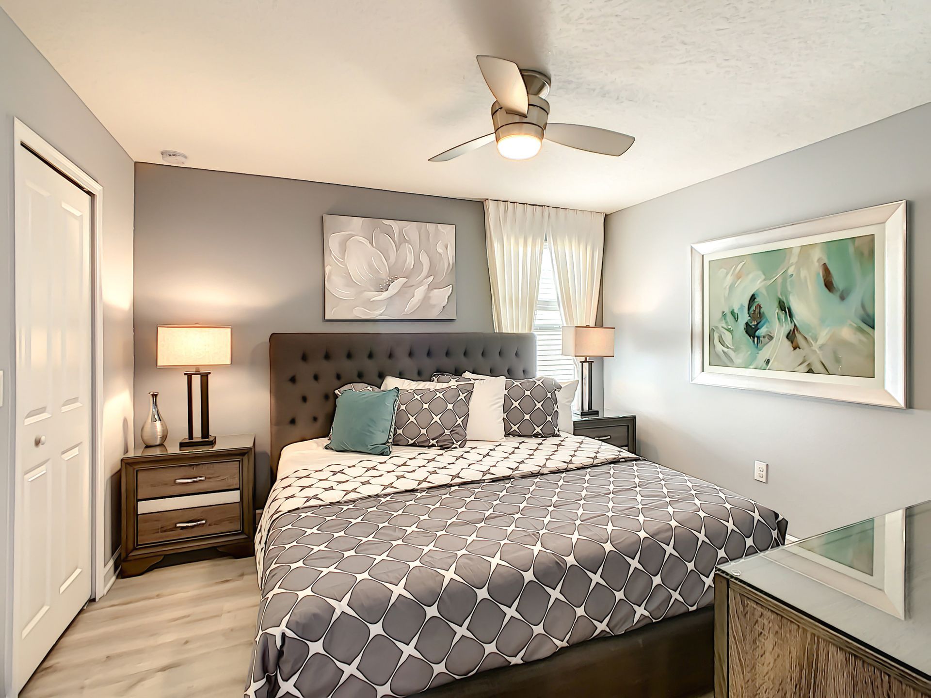 A bedroom with a king size bed and a ceiling fan.